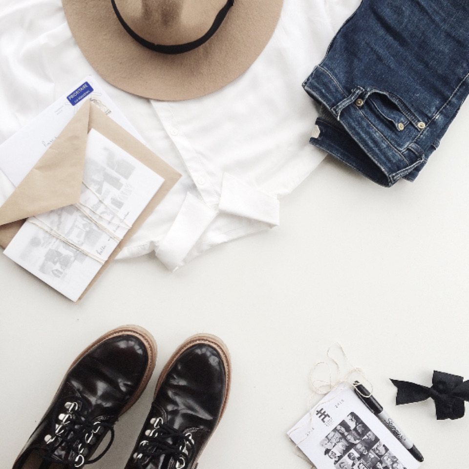 เสื้อเชิ้ตขาว ยีนส์ หมวก และรองเท้าจัดวางบนพื้นสีขาว